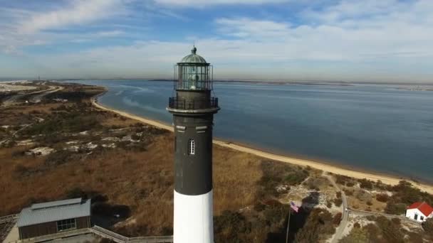 ドローンから見た灯台の海岸線空撮が晴れた冬の日にクローズ アップ — ストック動画