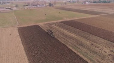 Amish çiftliği çalışanı havadan görünümü bir drone tarafından görüldüğü gibi erken baharda alanı tornalama