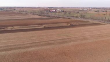 Amish çiftliği çalışanı havadan görünümü bir drone tarafından görüldüğü gibi erken baharda alanı tornalama