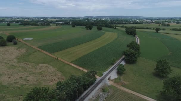 阳光明媚的一天 通过铁路轨道对阿米什农场土地的鸟瞰图 — 图库视频影像