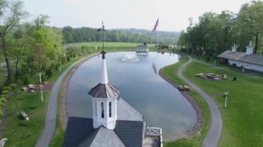 Bir bahar gününde bir gölet tarafından eski restore Barns havadan görünümü