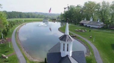 Bir bahar gününde bir gölet tarafından eski restore Barns havadan görünümü