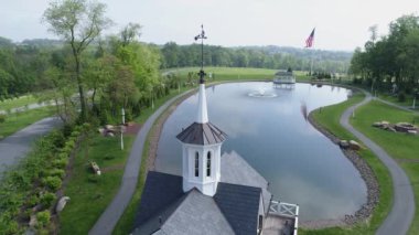 Bir bahar gününde bir gölet tarafından eski restore Barns havadan görünümü