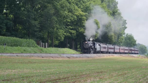 ランカスター ペンシルベニア州 2019年7月 晴れた夏の日にアーミッシュの田園地帯に沿って黒い煙を吹き飛ばす蒸気旅客列車 — ストック動画