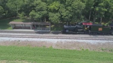 Ronks, Pennsylvania, Temmuz 2019 - Bir Drone tarafından görüldü olarak Güneşli bir Yaz Günü Amish Kırsal Boyunca Seyahat Yolcu Tren Puffing Duman ile 1910 Buhar Motoru Havadan Görünümü