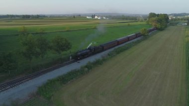 Ronks, Pennsylvania, Temmuz 2019 - Amish Kırsalı Boyunca Seyahat Eden Yolcu Treni ile 1924 BuharLı Motorun Havadan Görünümü, Bir Drone'un Gördüğü Bir Yaz Günü Gün Batımı olarak