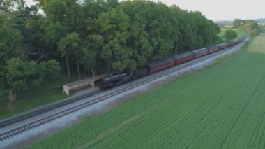 Ronks, Pennsylvania, Temmuz 2019 - Amish Kırsalı Boyunca Seyahat Eden Yolcu Treni ile 1924 BuharLı Motorun Havadan Görünümü, Bir Drone'un Gördüğü Bir Yaz Günü Gün Batımı olarak