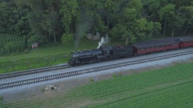 Ronks, Pennsylvania, Temmuz 2019 - Amish Kırsalı Boyunca Seyahat Eden Yolcu Treni ile 1924 BuharLı Motorun Havadan Görünümü, Bir Drone'un Gördüğü Bir Yaz Günü Gün Batımı olarak