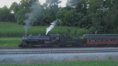 Ronks, Pennsylvania, Temmuz 2019 - Amish Kırsalı Boyunca Seyahat Eden Yolcu Treni ile 1924 BuharLı Motorun Havadan Görünümü, Bir Drone'un Gördüğü Bir Yaz Günü Gün Batımı olarak
