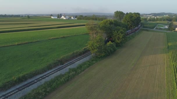 1924 年蒸汽机的鸟瞰图 乘客列车沿着阿米什乡村行驶 作为夏季日落的日落 由无人机看到 — 图库视频影像