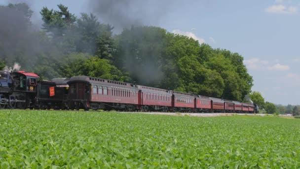 ロンクス ペンシルベニア州 2019年7月 晴れた夏の日に第二の蒸気機関車が通過するようにアーミッシュの田園地帯に沿って黒い煙を吹き込む駅に引っ張る旅客列車と1910蒸気機関 — ストック動画