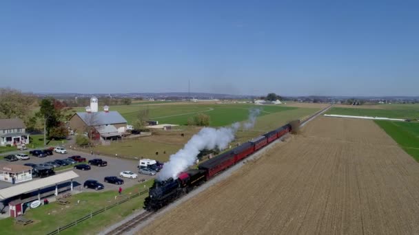 黒と白の煙と蒸気を吹いているとして田舎を旅する乗用車とアンティーク復元蒸気機関車の空中ビュー — ストック動画