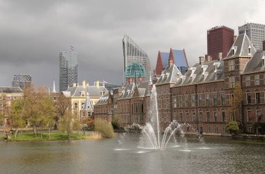 Hofvijver gölet Binnenhof governmet binalar ve modern ofis binaları ile uçan Hollanda bayrağı yanındaki Çeşme.