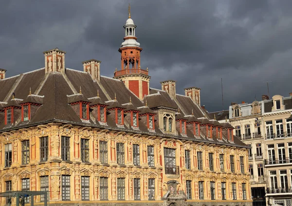 The old Stock Exchange building in Lille, France in the sun against a sky with rainclouds