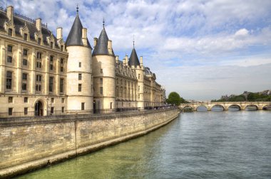 Paris, Fransa - 12 Mayıs 2018: Tarihsel Conciergerie binalar ve 12 Mayıs 2018 Paris'te Seine boyunca köprüyü geçtikten insanlar