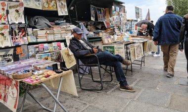Paris, Fransa - 12 Mayıs 2018: Paris, Fransa, Seine Nehri boyunca onun kitap stalll, 12 Mayıs 2018 üzerinde oturan adam