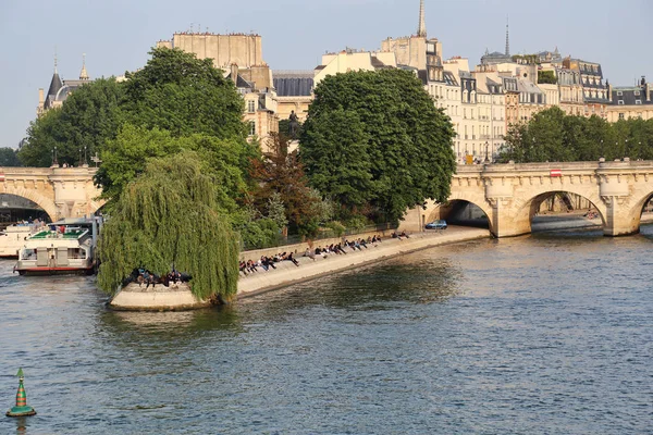 フランス 2018 夕日と 2018 日にフランスのパリでセーヌ川の土手に座っている人々 の歴史的建造物 — ストック写真