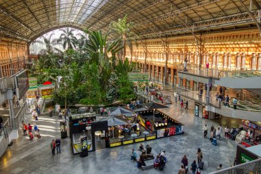 Madrid, İspanya - 28 Mayıs 2016: 28 Mayıs 2016 'da İspanya' nın Madrid kentindeki Atocha tren istasyonundaki tropikal bahçenin altındaki bir kafede insanlar oturuyor