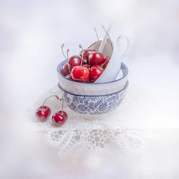 Kirschen Einer Alten Porzellantasse Auf Dem Tisch Mit Häkelarbeit — Stockfoto