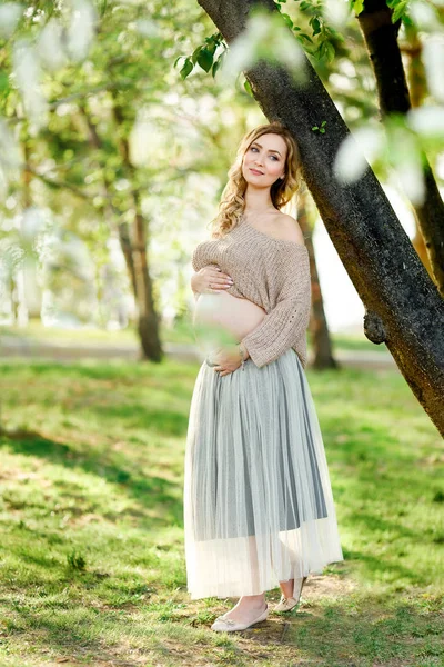 Беременность, люди и материнство - счастливая беременная азиатка, гуляющая в парке . — стоковое фото