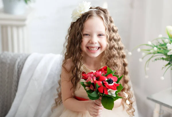 Çocuk - taç sarı saçlı kız. Parlak bir stüdyoda Güzel küçük kız oturur, lauht ve kameraya bakar