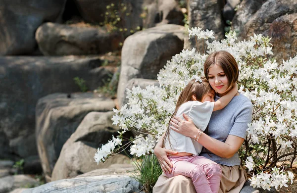 Mother hugs lovely child daughter in white flowers field. Family Relationship and Love Concept — Stock Photo, Image