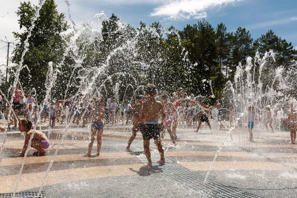 Khabarovsk. Rusko. 26 Jule 2017. Spousta dětí si hraje s fontánou za horkého a slunného letního dne. — Stock fotografie