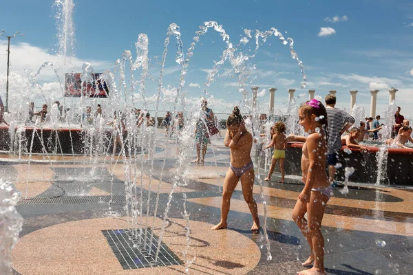 Khabarovsk. Rusko. 26 Jule 2017. Spousta dětí si hraje s fontánou za horkého a slunného letního dne. — Stock fotografie