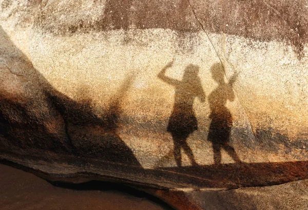 Silhouette of two female figures on a big stone in summer sunny day — Stock Photo, Image