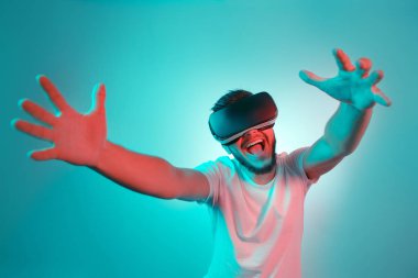 VR kulaklık çalışıyor ve renkli arka plan üzerinde başka bir dünya keşfetmek yakışıklı sakallı adam. VR mezartaşı ile kullanılarak akıllı telefon.