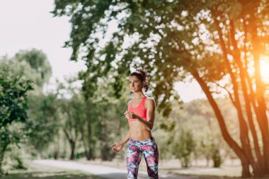 Genç kadın atlet açık egzersiz sırasında bir parkta koşu. Güzel kız uygun. Kilo kaybı. Spor yaşam tarzı.