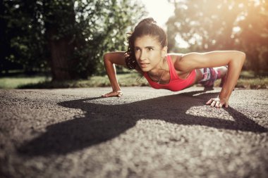 Genç kadının sunse parkta egzersiz yukarı itin yapması uygun. Spor motivasyon. Sağlık kavramı.