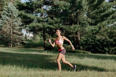 Genç kadın atlet açık egzersiz sırasında bir parkta koşu. Güzel kız uygun. Kilo kaybı. Spor yaşam tarzı.