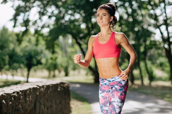 Jovem jogging corredor feminino durante o treino ao ar livre em um parque. Linda garota apta. Perda de peso. Estilo de vida desportivo . — Fotografia de Stock