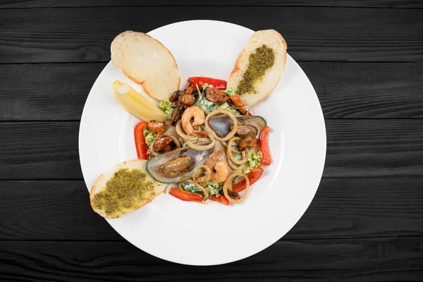 Deniz ürünleri salatası. Midye ve karides beyaz bir plaka üzerinde.