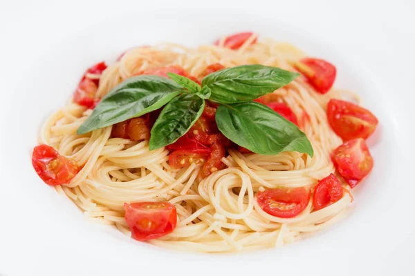 Siyah bir ahşap zemin üzerine beyaz tabakta Domatesli makarna.