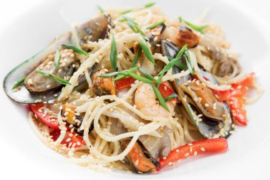 Karides ve beyaz tabakta midye makarna.