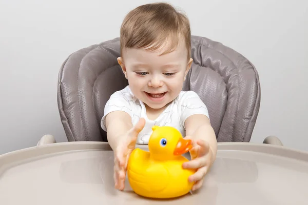 Mutlu sevimli bebek boy oynayın ördek oyuncak yüksek sandalye ile.