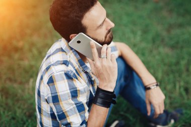 Çekici genç hipster cep telefonu ile sakallı. Sakallı adam cep telefonu üzerinde konuşurken.