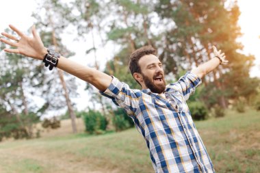 Mutlu heyecanlı kutluyor sakallı adam parkta eller UPIN ile poz.