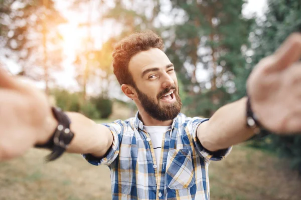 Enthousiast jonge hipster man maken selfie in het park bij de zonsondergang. — Stockfoto