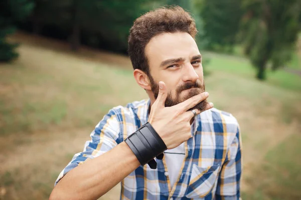 Jeune hipster barbu couper la barbe avec le doigt. Concept de salon de coiffure . — Photo