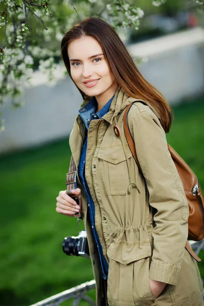 Young beautiful woman walking in the park. Traveler with vintage camera. — Stock Photo, Image
