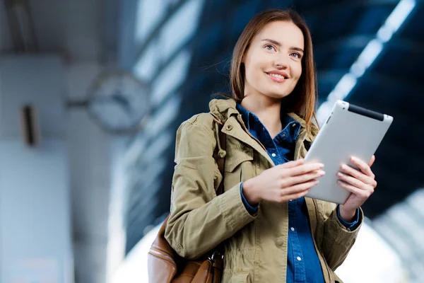 Tren İstasyonu platformu üzerinde duran tablet kullanma sırt çantası olan kadın
