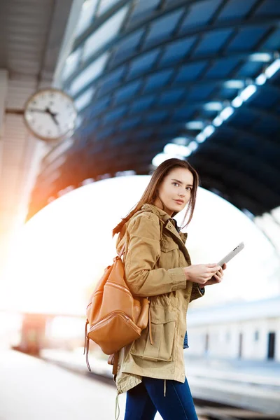 Tren İstasyonu platformu üzerinde duran tablet kullanma sırt çantası olan kadın.