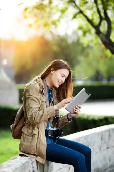 Genç kadın rahat kıyafetler kısa tablet üzerinde günbatımında mesaj.