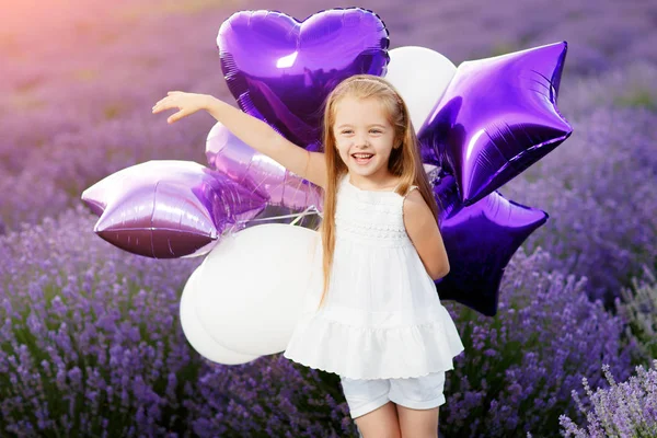 幸せなかわいい女の子が紫の風船でラベンダー畑。自由の概念. — ストック写真