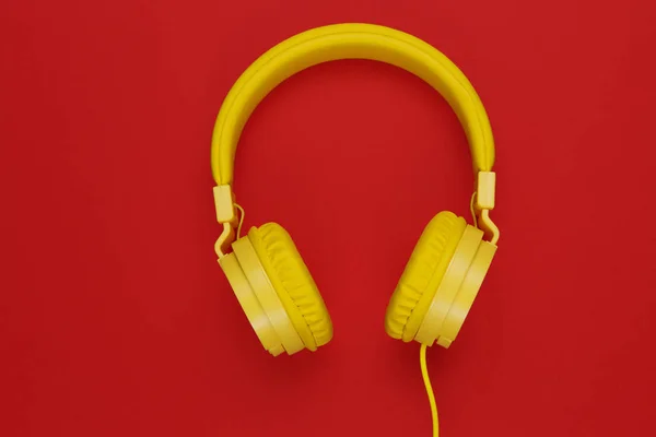 Auriculares amarillos sobre fondo rojo. Concepto musical . —  Fotos de Stock