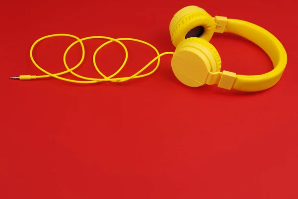 Желтые наушники на красном фоне. Концепция музыки . — стоковое фото