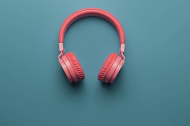 Mavi arka plan üzerinde pembe kulaklık. Müzik konsepti